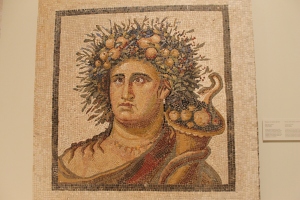The Genius of the Year was a spirit that watched over the inhabitants of the Roman villa in which this mosaic was found. Part of this protection extended to their food and drink, including wine.